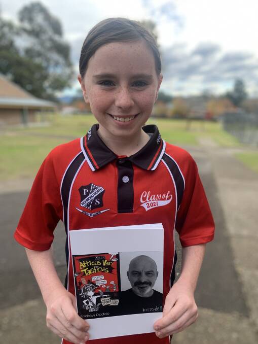 North Richmond Public School student Emily with a copy of the book the students wrote based on Andrew Daddo's Atticus Van Tasticus. 