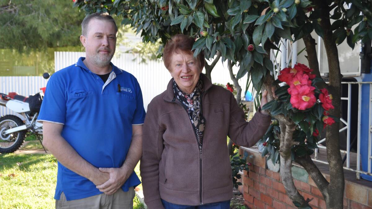 Jodey-Lee Riddell with Denise Di Salvia. Mr Riddell inherited his camellias from his home's previous owner. With the help of Mrs Di Salvia and others in the Narrandera Gardening Club he has won several first prizes.