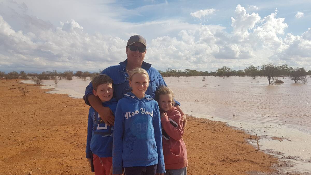 Luke Mashford with children, George, 10, Jess, 12 and Nicola, 8 after their flood country finally got a drink earlier this year. Photo: Supplied