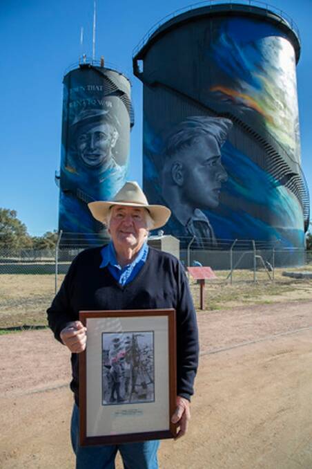 Mike Cannon, at the painted water tower in Hay which features the portrait of his father George. Photo: Margie McClelland 