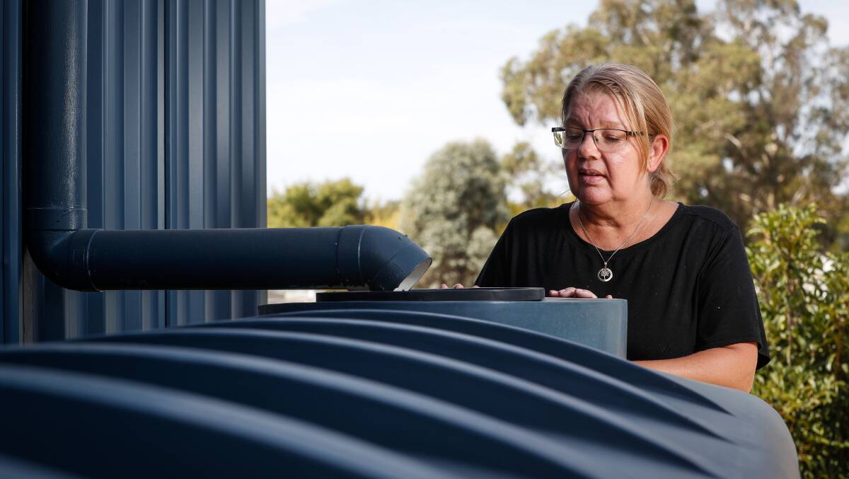 Nothing there: Carol Ziebarth looks into one of her tanks that were installed to help with her garden. Picture: JAMES WILTSHIRE