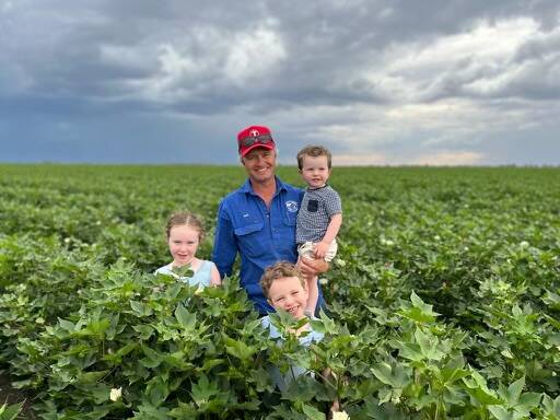 Weemelah grower Sam Hegarty, South Bunarba, in his cotton crop holding Walter, with Sybil and Charlie.