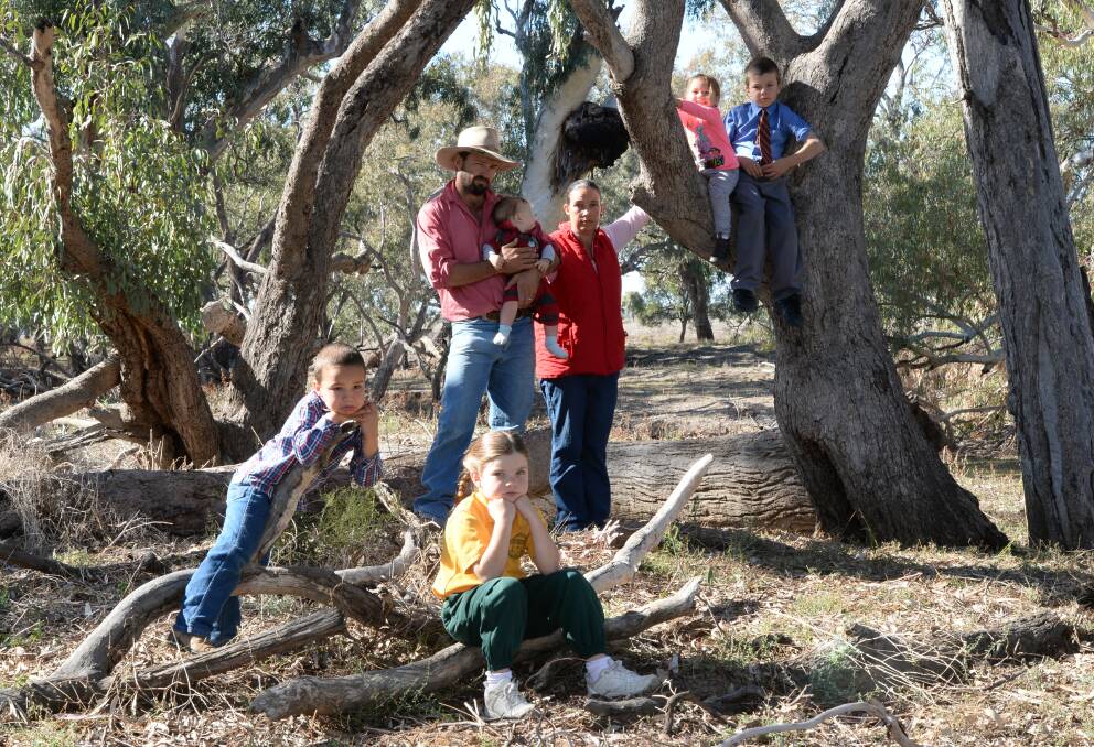 The Macraes of Coonamble have had their lives thrown up in the air by the proposed Pilliga pipeline. From left, George, 5, Isobel, 7, their father, Adam, with Barney, 8 months, their mother, Row, Audrey, 2, and Oscar, 9, on their farm, "Tyrone".