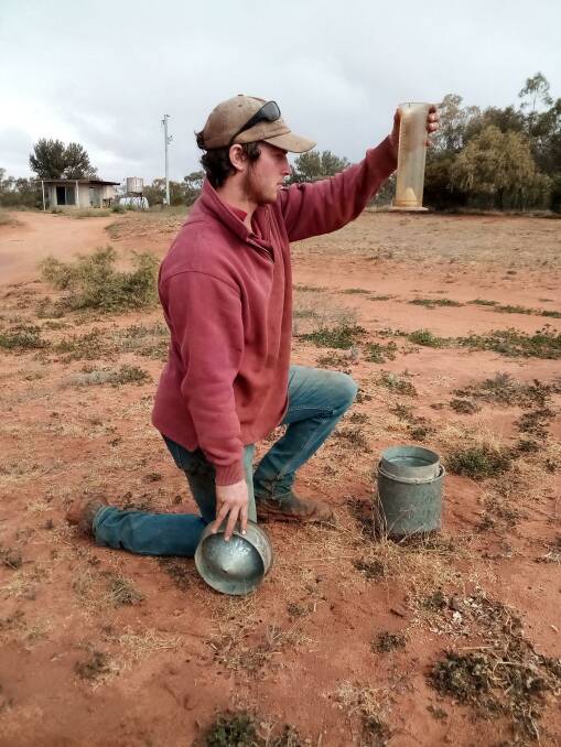 Kiwi jackeroo Luke Hillis checks the rain gauge at Langawirra where 15.6mm fell on Friday morning, north of Broken Hill. Photo by Lachlan Gall. Some stations nearby only received a few millimetres.