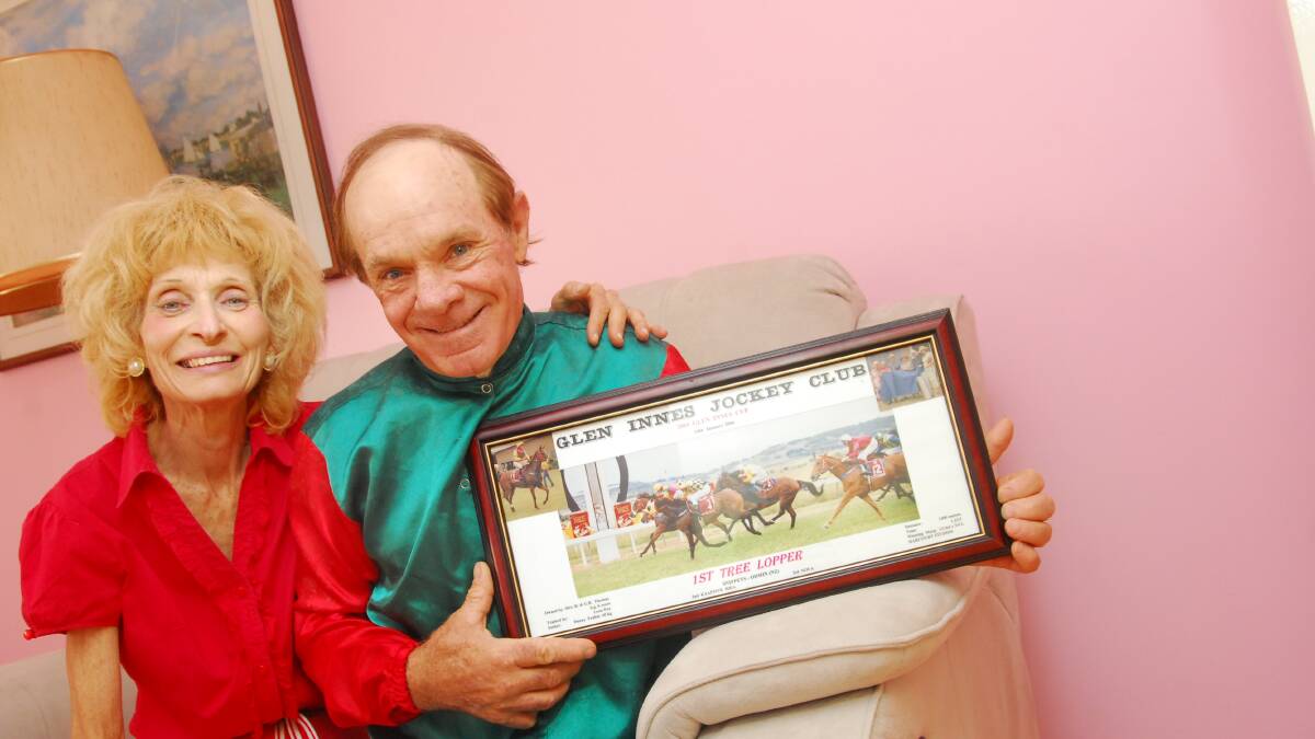 The late Danny Frahm and wife Mireille in Moree, with a photo of him winning the Glen Innes Cup aboard Tree Lopper in 2004. Photo The Land 