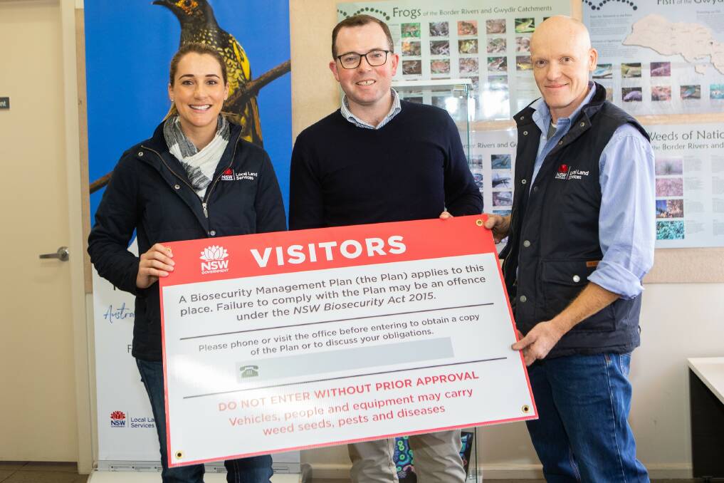 Northern Tablelands LLS biosecurity officer Elli Sinclair, Agriculture Minister Adam Marshall, and Northern Tablelands LLS general manager Paul Hutchings with the in-demand signs.