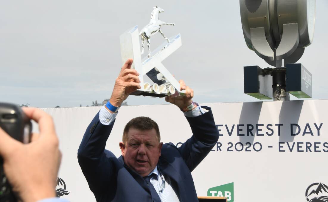 A relieved Scone trainer Brett Cavanough holding up The Kosciuszko trophy after the win of It's Me. Photo Virginia Harvey. 