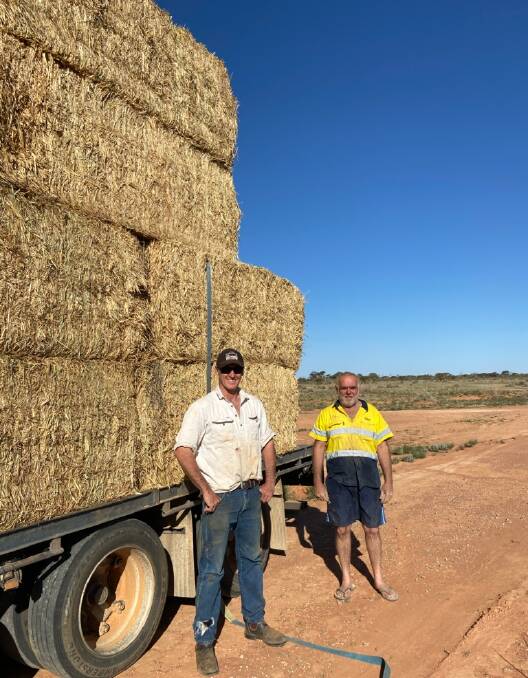 Nice to see you ... Matt Jackson, Rowena Station, north-east of Broken Hill with Rural Aid driver David Moore and the timely hay delivery. Photos by Sara Jackson.
