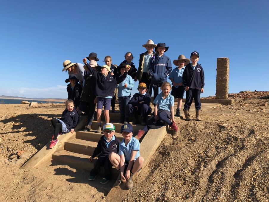 Adaminaby's public school students on a visit to the ruins of the old town of Adaminaby now revealed as the level of Lake Eucumbene plummets. Pictures except for hat throwing one courtesy of Kerrie Mault.