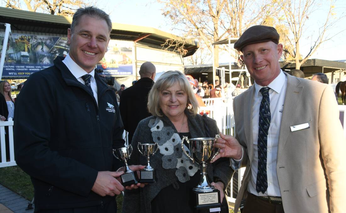 Manager of Muswellbrook Race Club Duane Dowell, and president John Sunderland (right) with Lyn Snowden with Shorty Cribb Memorial Aberdeen Cup trophies. Photo Virginia Harvey.