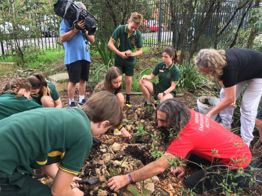 PLANTING IDEAS: Costa Georgiadis encourages Camdenville Public School students to see what goes on a ground level when planting shrubs.