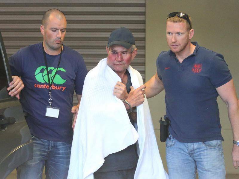 NABBED: Police officers take Gino Stocco into Dubbo Police Station after he and his son Mark were arrested in Dunedoo in October 2015. Picture: AAP 