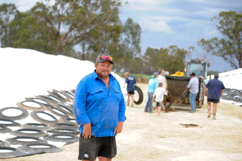 Greg Clark with his team busy covering the silage pad. 