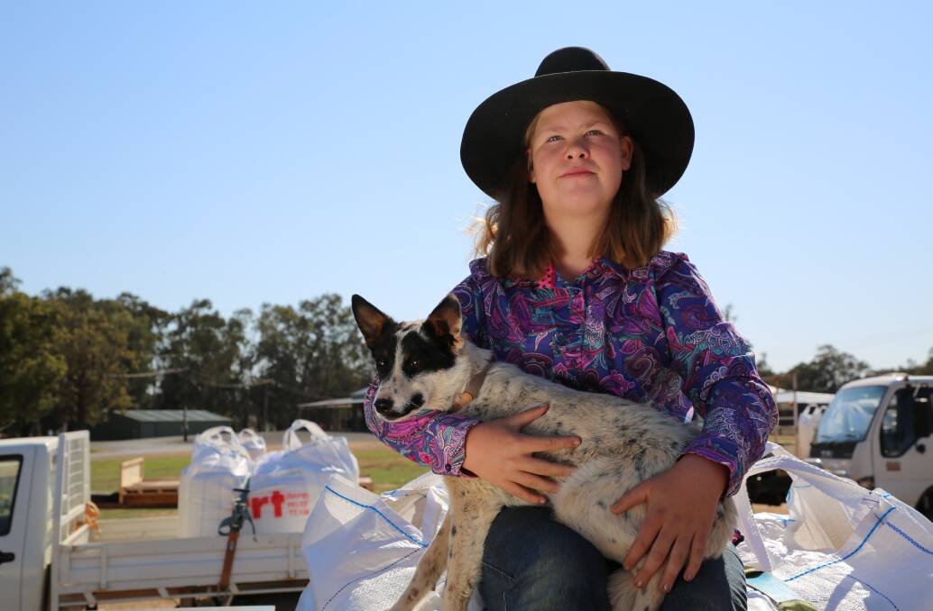 A young girl and her dog with some of the donated feed. Photos: Supplied