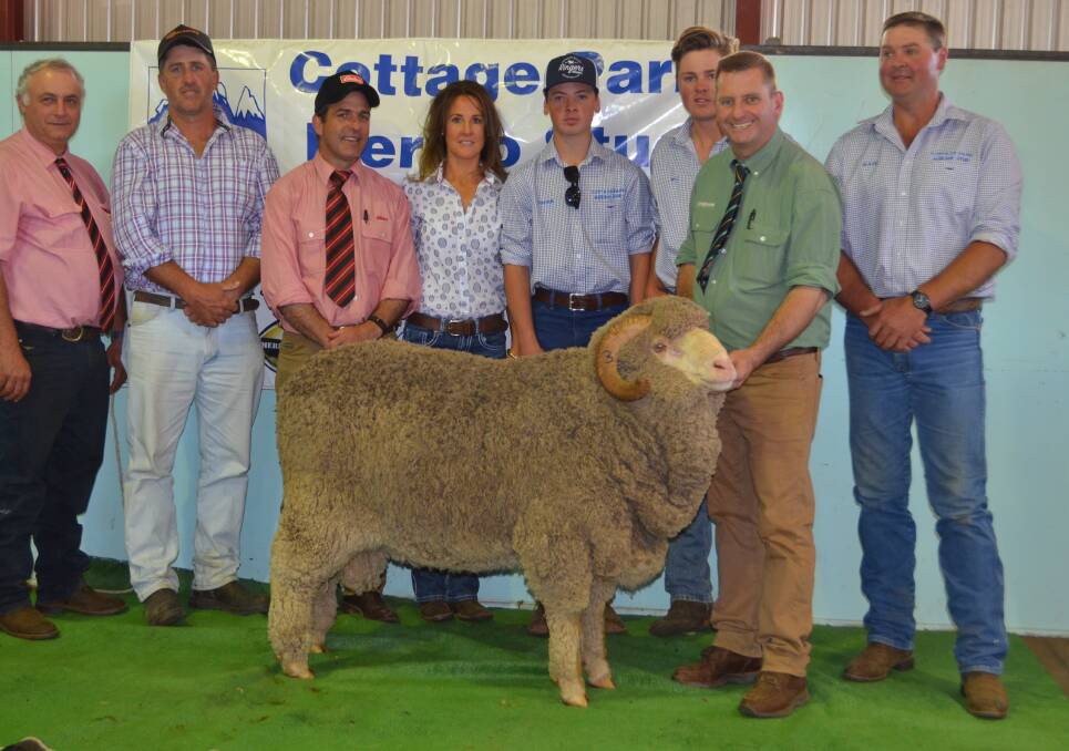 ABOVE: The $31,000 Merino ram at Cottage Park with Sam Green, Elders, Cooma, vendors Jodie, Charlie, Will and Mark Pendergast, and Landmark auctioneer Rick Power. Photo: Stephen Burns