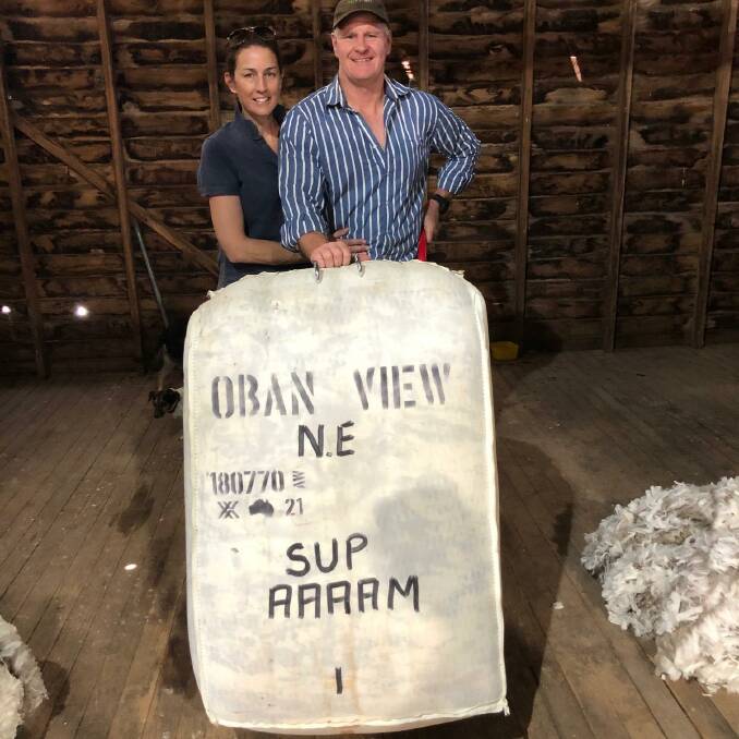 Claire and Jon Welsh with their first pressed bale of Merino wool at Oban View, Guyra. 