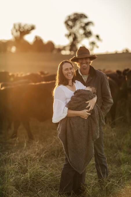 The Lowe family of Jenna, Dan and baby Clyde at Achill North on the outskirts of Armidale in front of a mob of their Brangus cattle. 