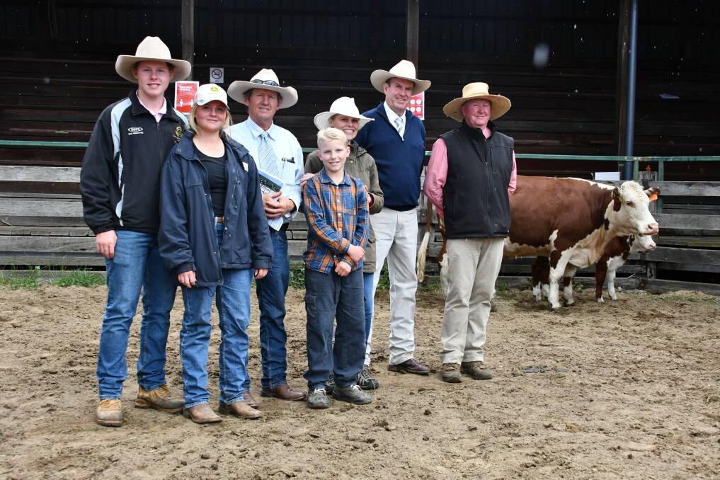 Hugo, Cilla, Ben, Oscar and Annabelle Monie, auctioneer Paul Dooley and Elders agent Dick Gleeson with one of the equal top price females that was sold to Franco Herefords. 