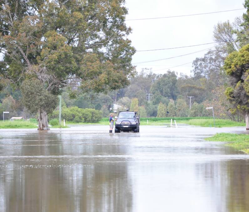 A flooded road at Forbes earlier this week. Many roads are still closed in the Central West and preventing farmers from moving cattle and lambs to market.