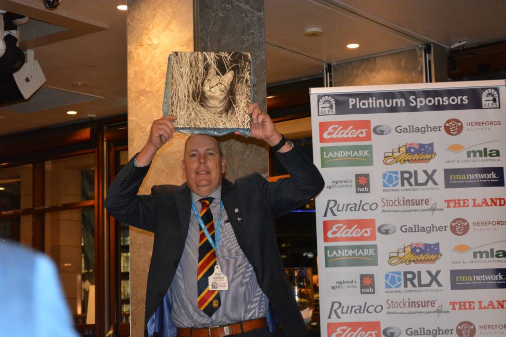 ALPA president Warren Johnston, Launceston, showing off one of the many items auctioned for charity during the ALPA National Young Auctioneers Competition dinner. 